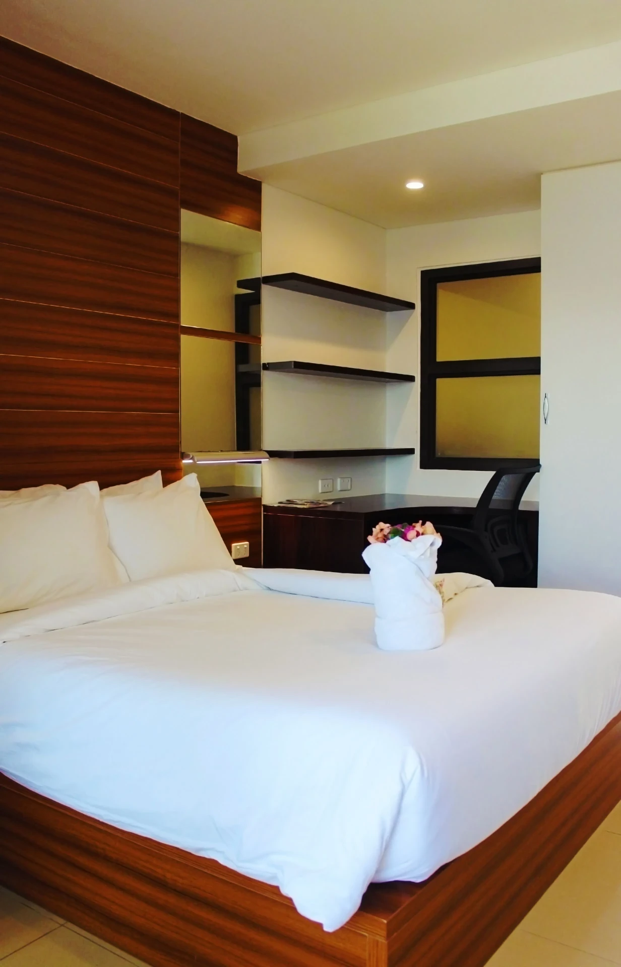 Queen bed, timber headboard and work desk in a Nambis Inn room